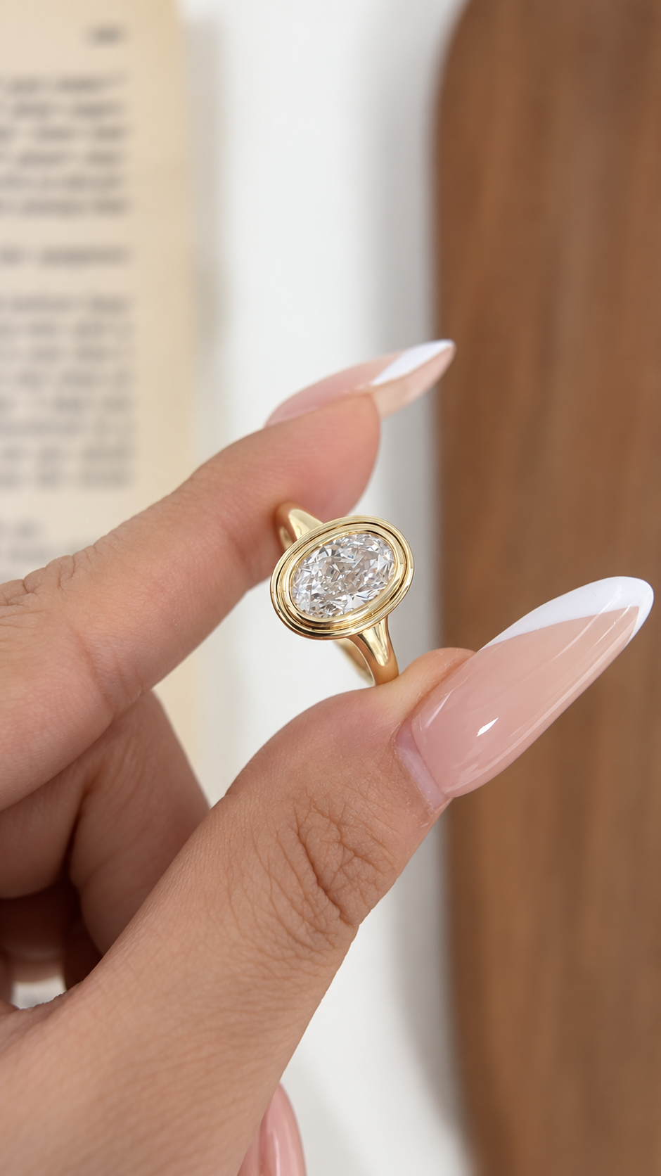 Front view of 2 ct oval lab-grown diamond bezel solitaire ring in yellow gold