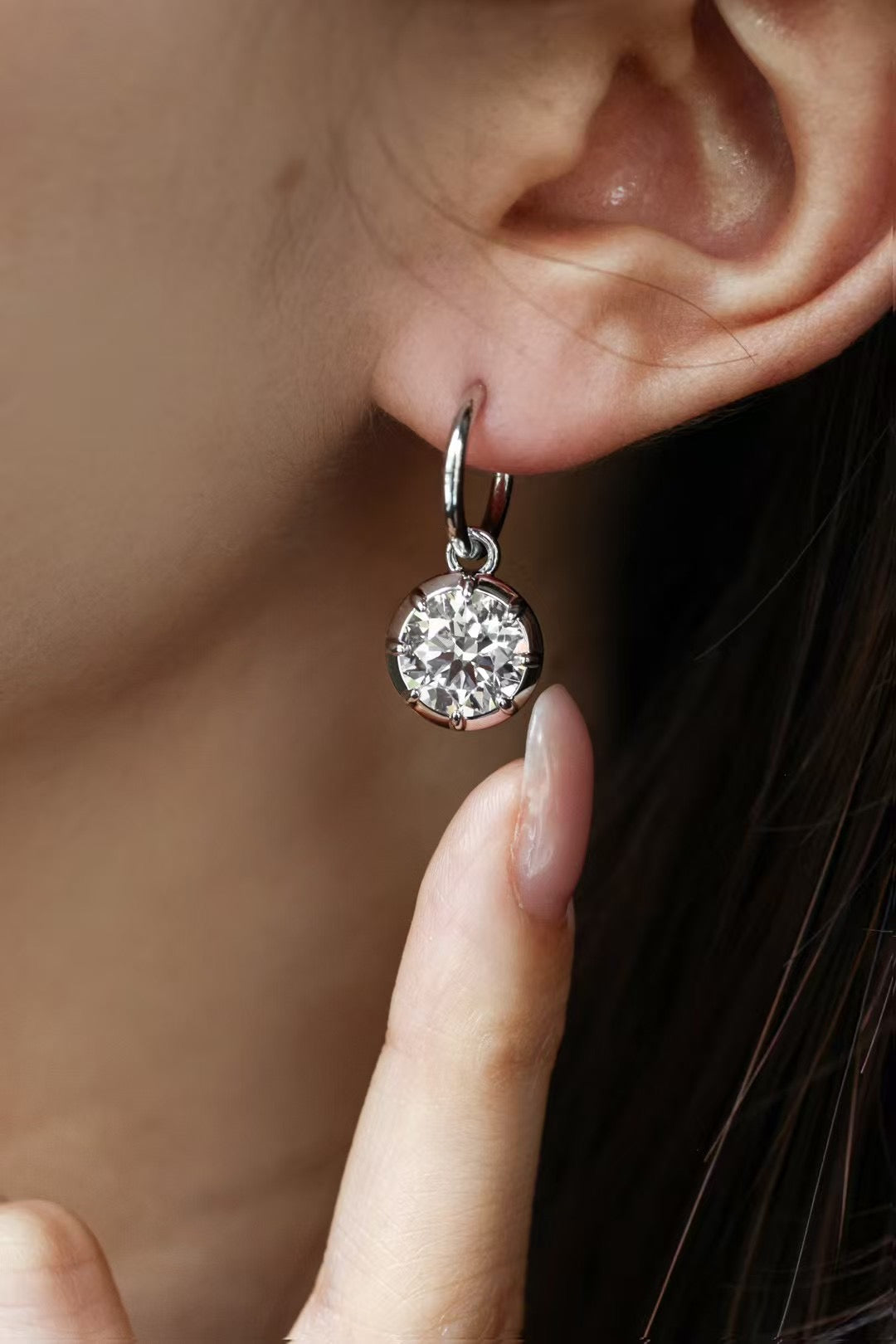 Round lab-grown diamond bezel drop earrings in 18K gold, worn on ear