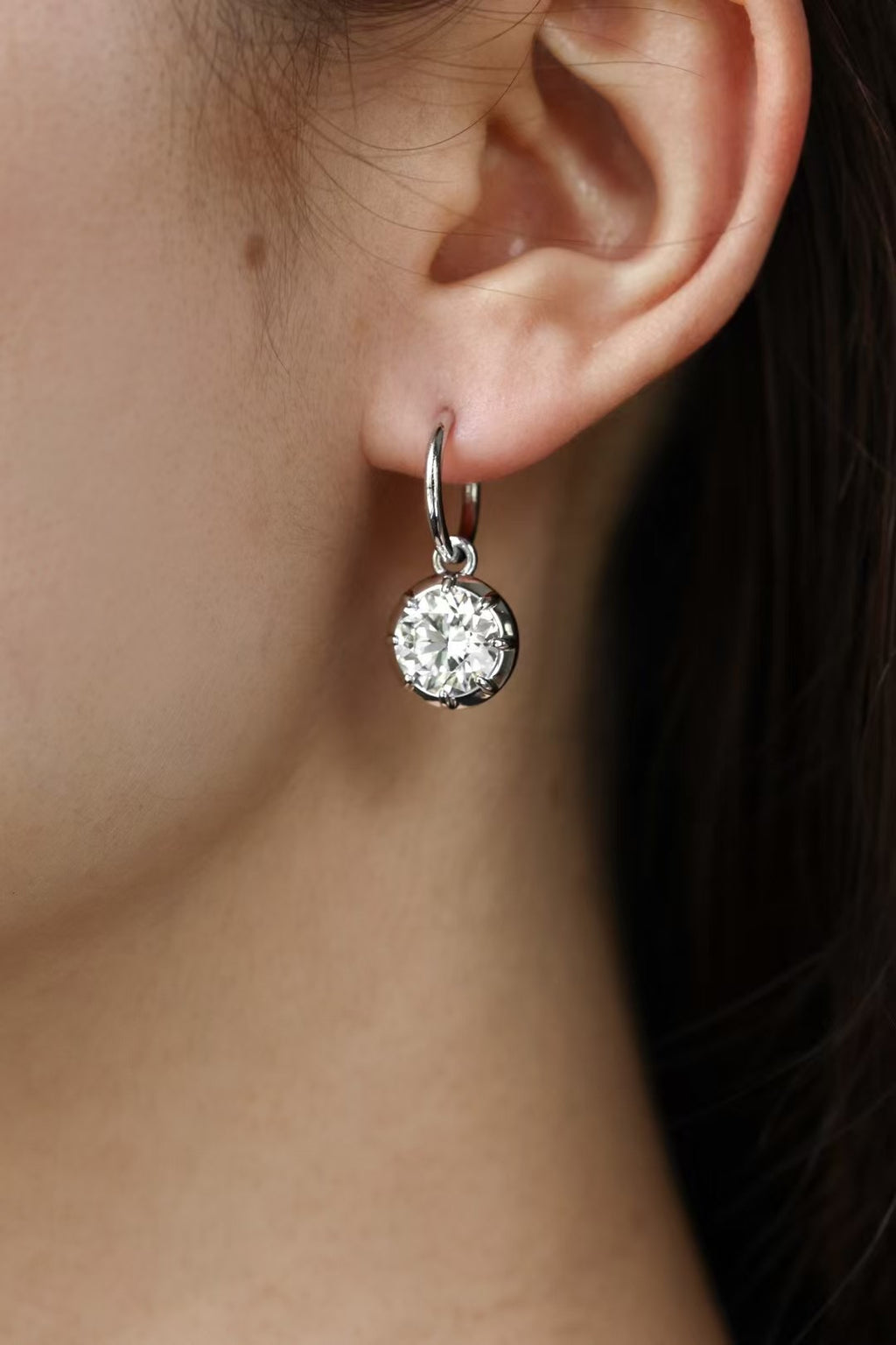 Round lab-grown diamond bezel drop earrings in 18K gold, worn on ear