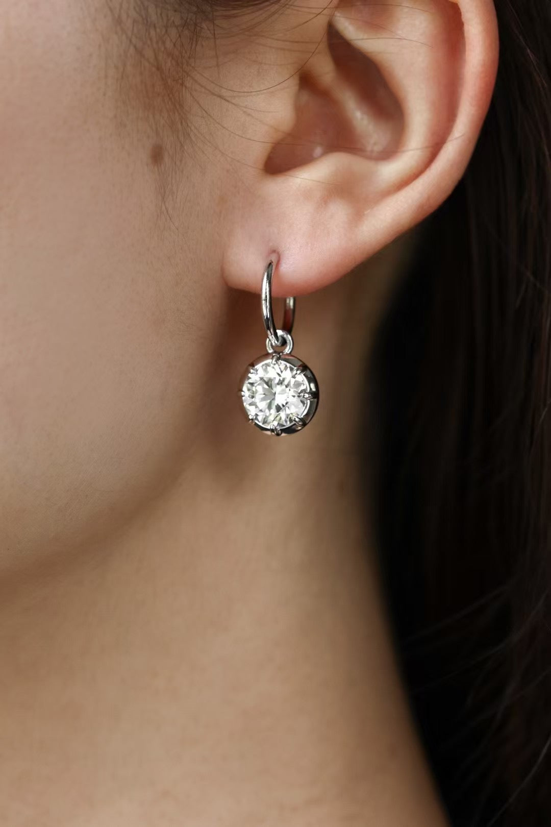 Round lab-grown diamond bezel drop earrings in 18K gold, worn on ear