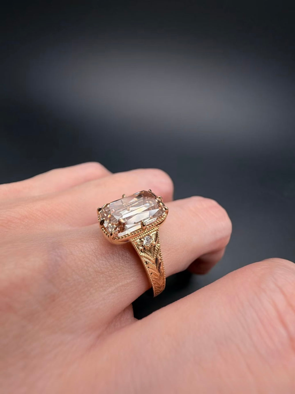 Angled on-hand view of champagne elongated cushion lab-grown diamond ring in yellow gold