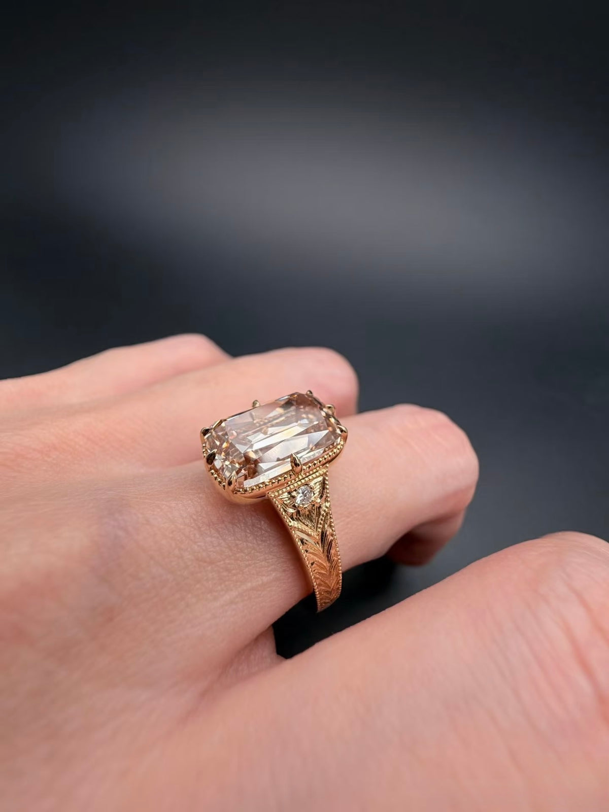 Angled on-hand view of champagne elongated cushion lab-grown diamond ring in yellow gold