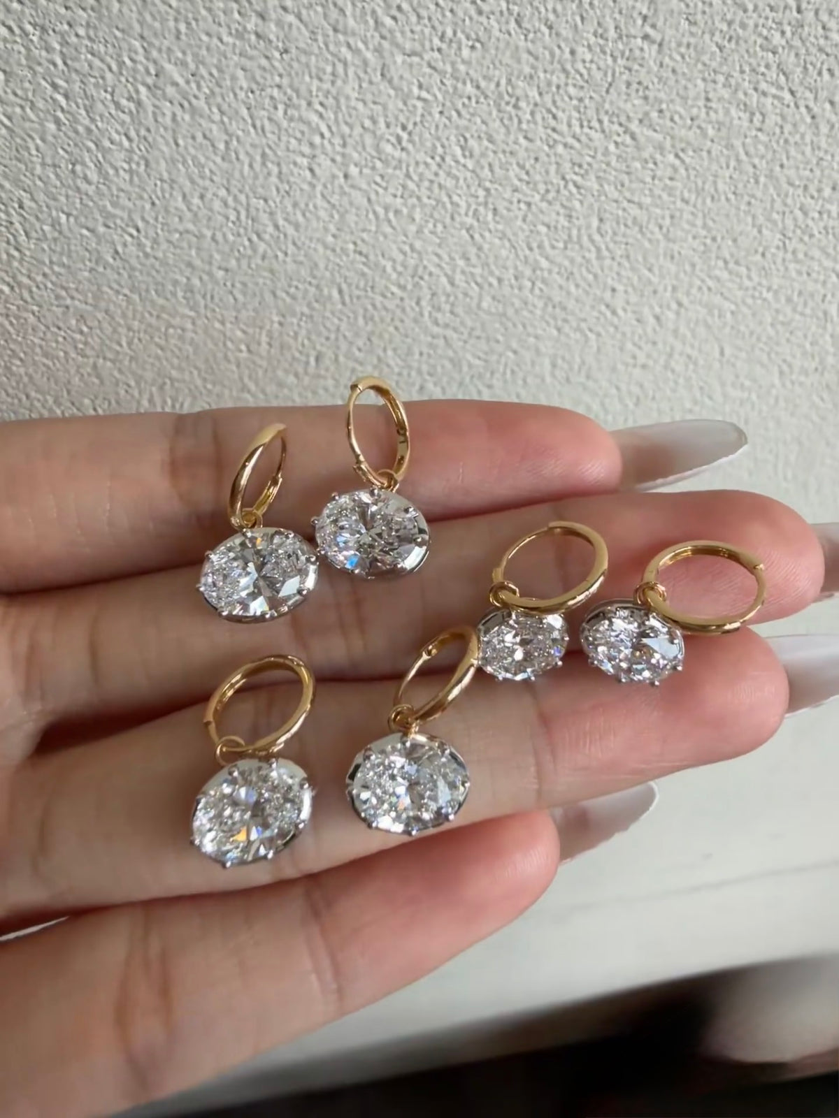 Multiple pairs of oval diamond-style earrings shown together; listing is for one pair