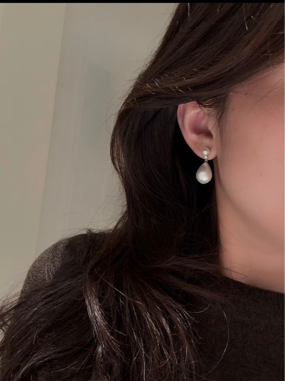 Freshwater pearl and natural diamond drop earrings worn on the ear