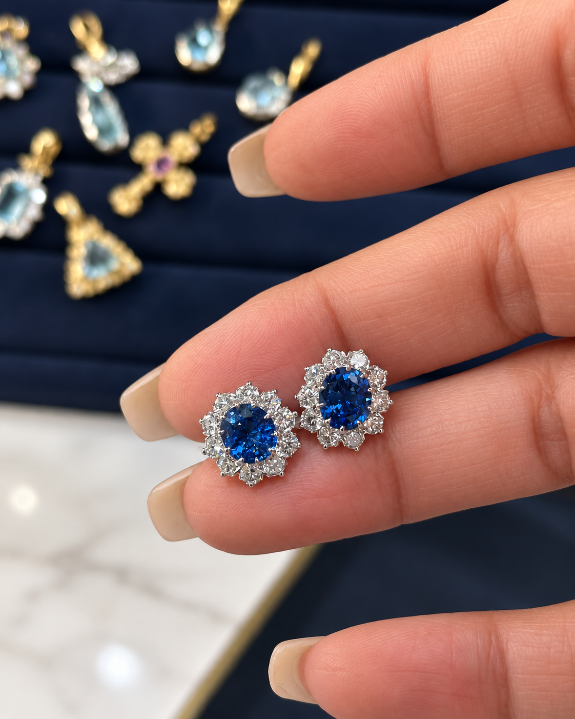 Pair of natural sapphire platinum stud earrings held in hand
