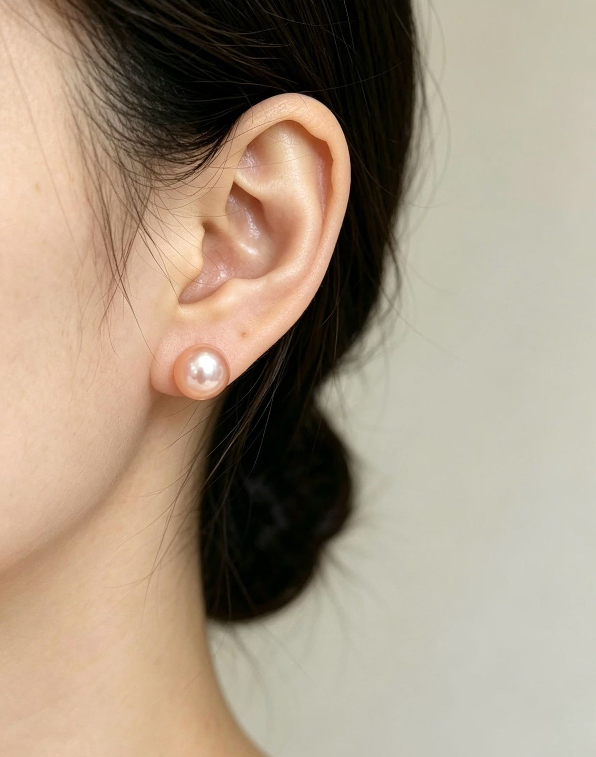Pink-lavender freshwater pearl stud earring worn on the ear