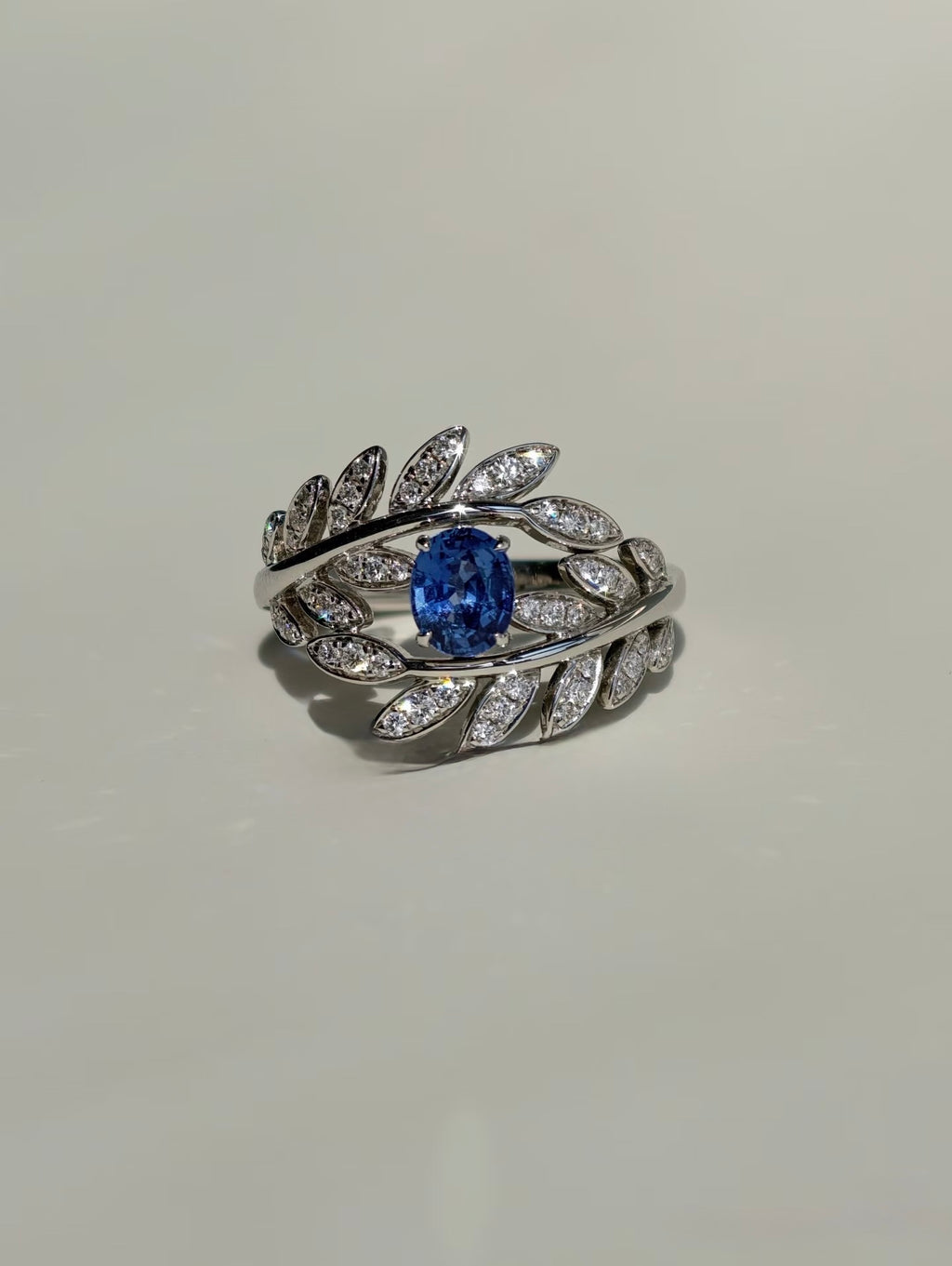 Royal blue sapphire ring with natural diamond leaf details in 18K gold