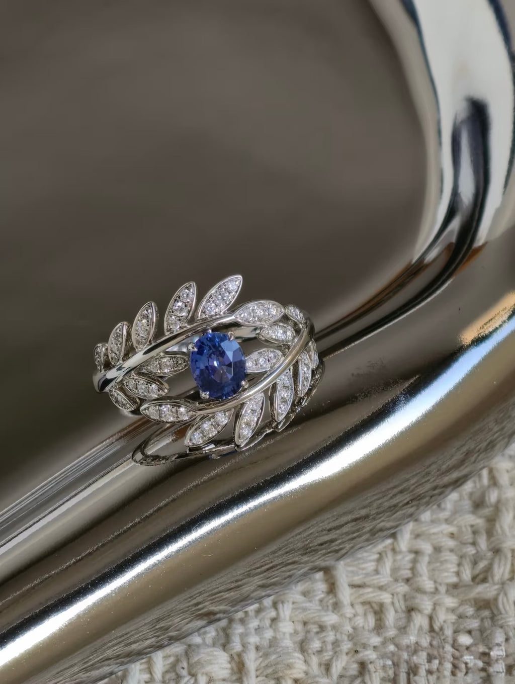 Close-up of oval sapphire and diamond leaf setting