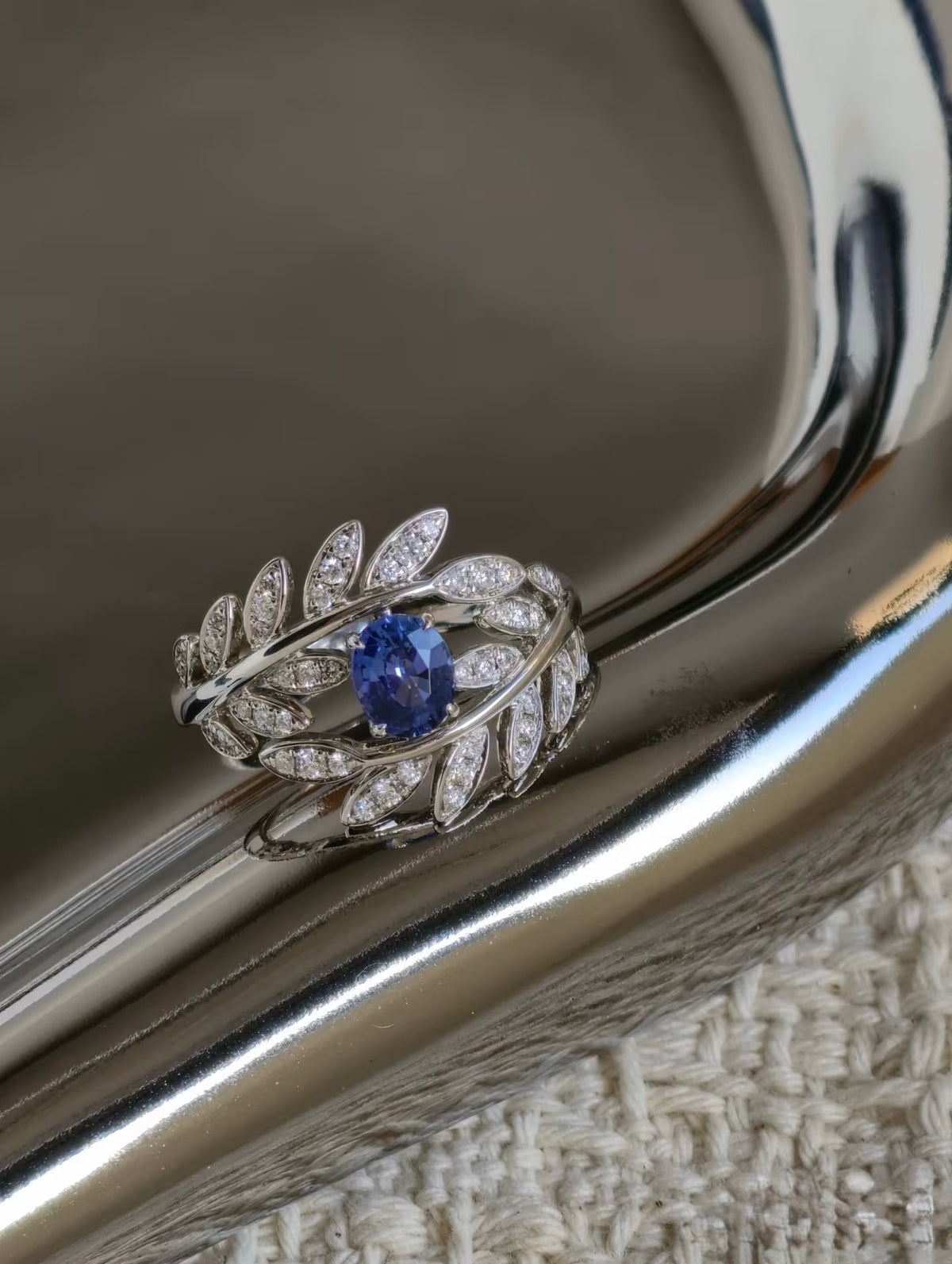 Close-up of oval sapphire and diamond leaf setting