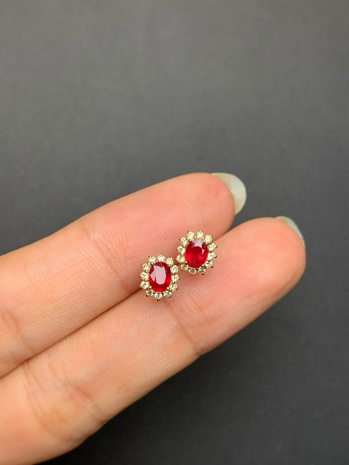 Pair of pigeon blood red ruby and natural diamond stud earrings in 18K gold