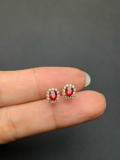 Pair of pigeon blood red ruby and natural diamond stud earrings in 18K gold