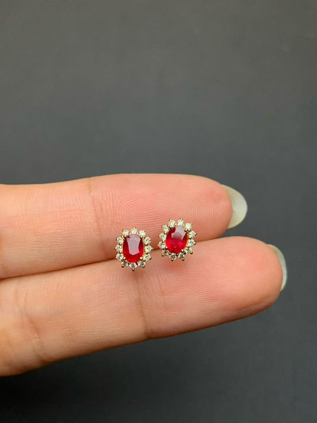 Pair of pigeon blood red ruby and natural diamond stud earrings in 18K gold